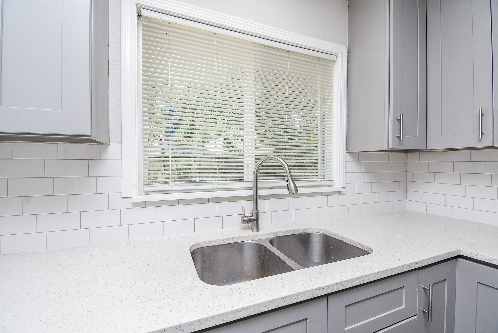 7406 Schiller Street, Houston, TX 77055 White quartz countertops and dual basin sink with brushed nickel fixture.