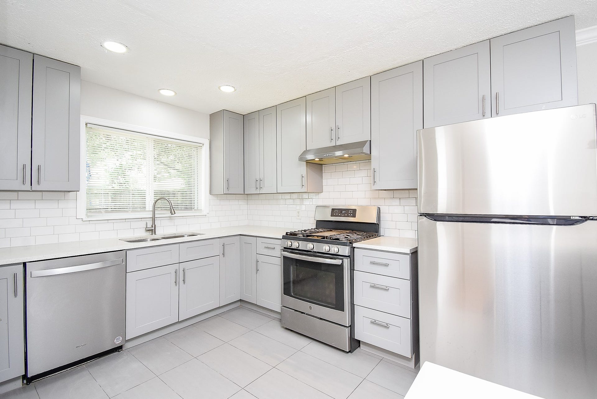 7406 Schiller Street, Houston, TX 77055 Trendy grey kitchen cabinets with stainless steel appliances.