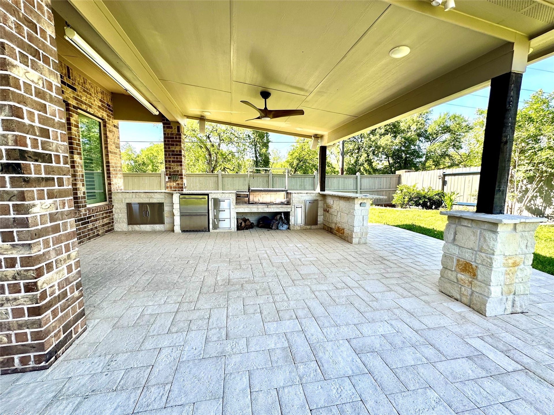Covered patio in backyard with elegant outdoor kitchen
