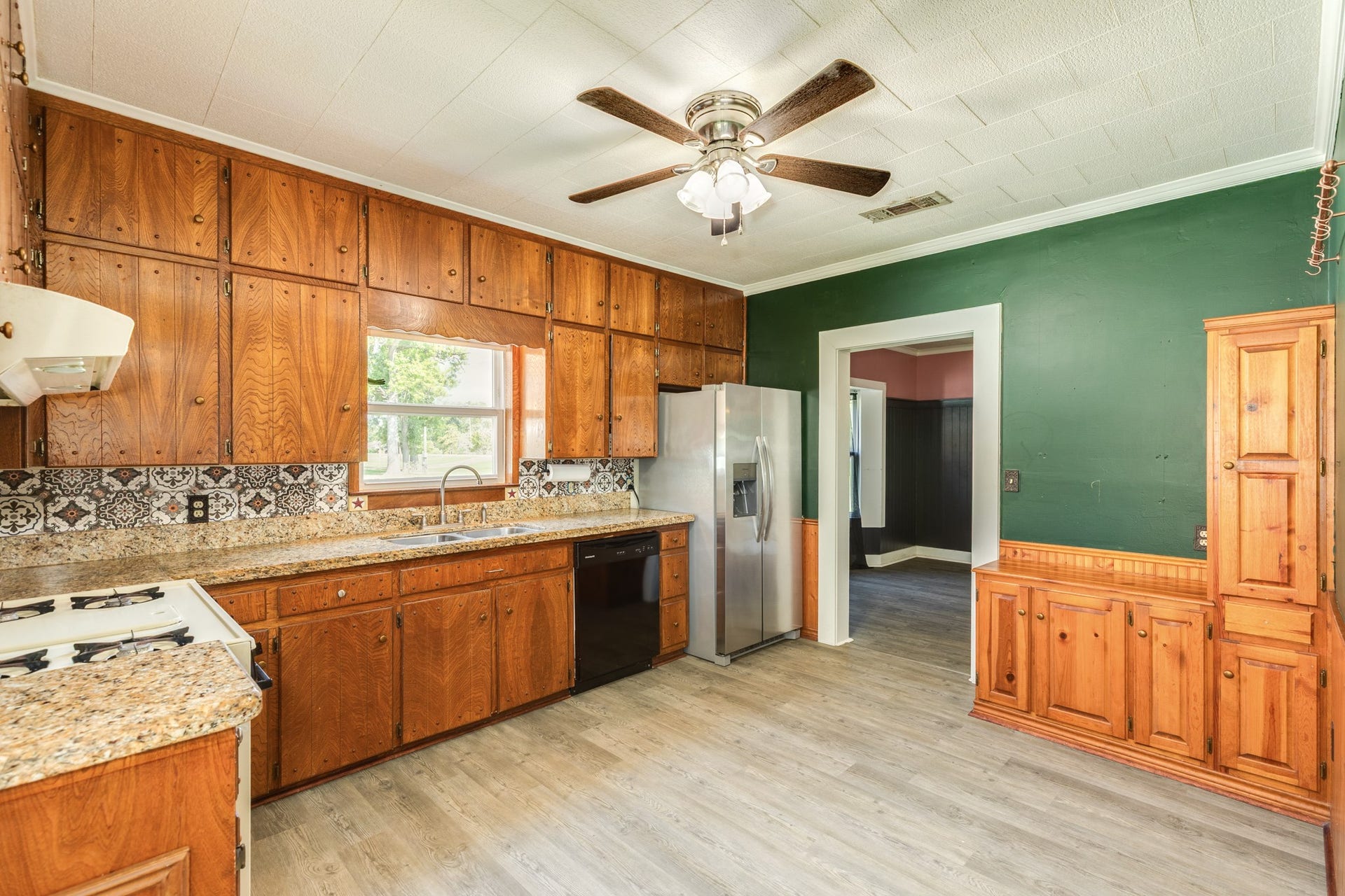 Custom original cabinetry, granite countertops, and moodt paint gives this kitchen the vintage cottage feel as soon as you walk in!