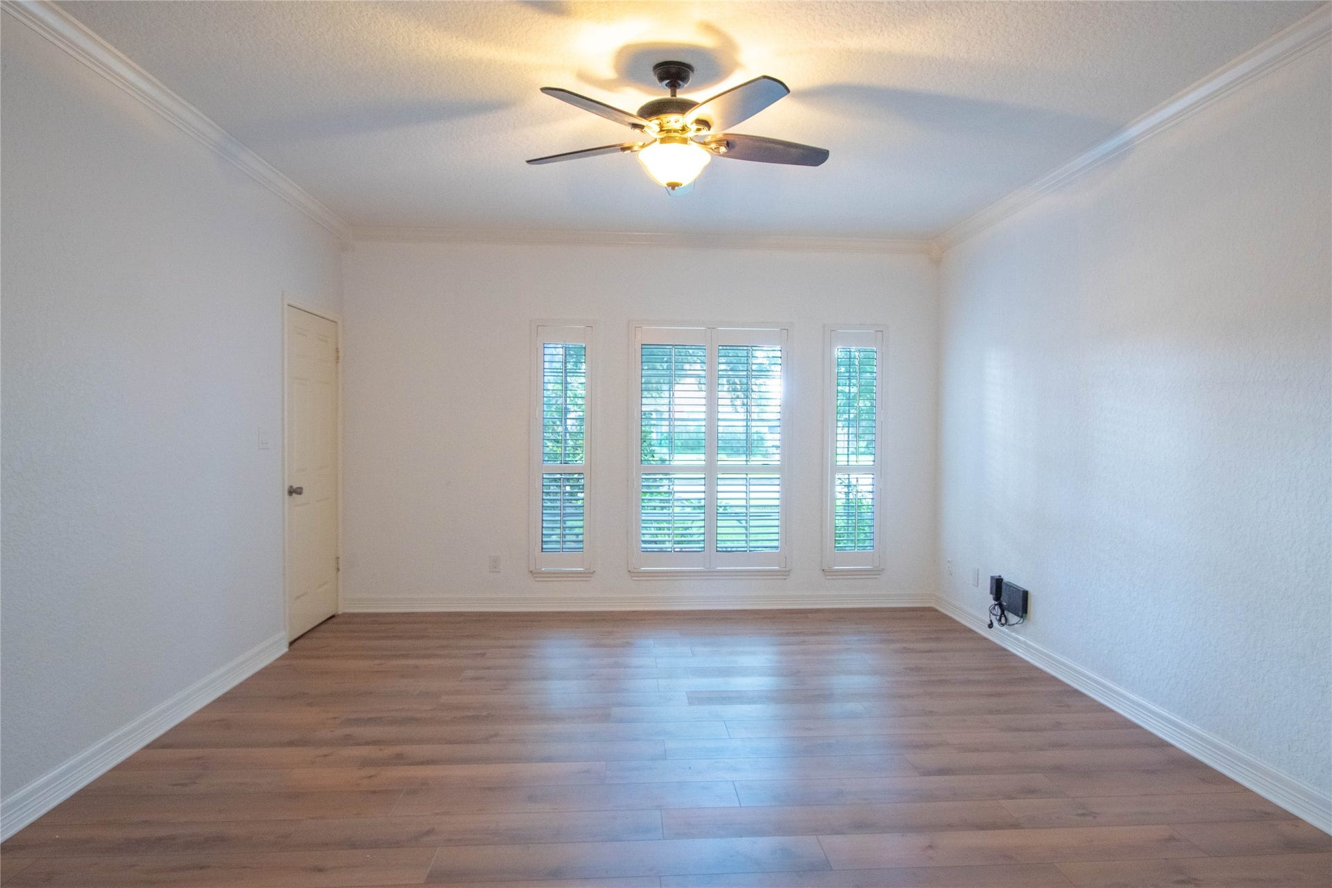 4700 Broadmoor Drive, League City, TX 77573 Actual picture of Main bedroom downstairs. with laminated flooring and windows with shutters overlooking the front yard.