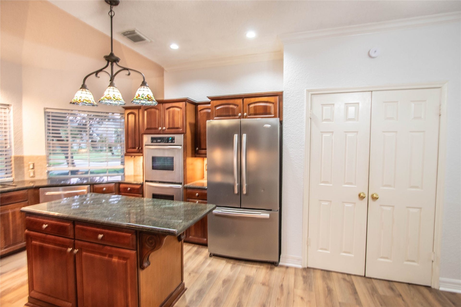 4700 Broadmoor Drive, League City, TX 77573 The right side of the kitchen with double ovens, a refrigerator, table island and the pantry.