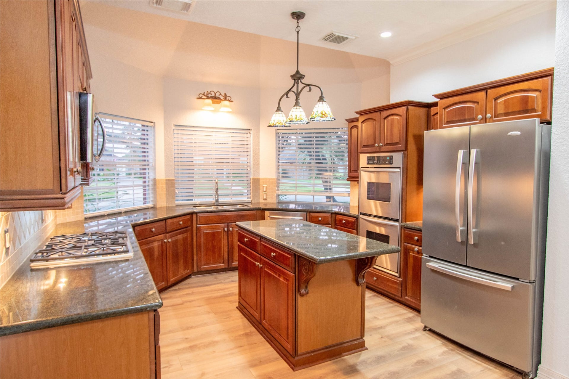 4700 Broadmoor Drive, League City, TX 77573 The kitchen with mohagamy wood cabinets has plenty of counter space and three bay windows that overlook at the front yard.