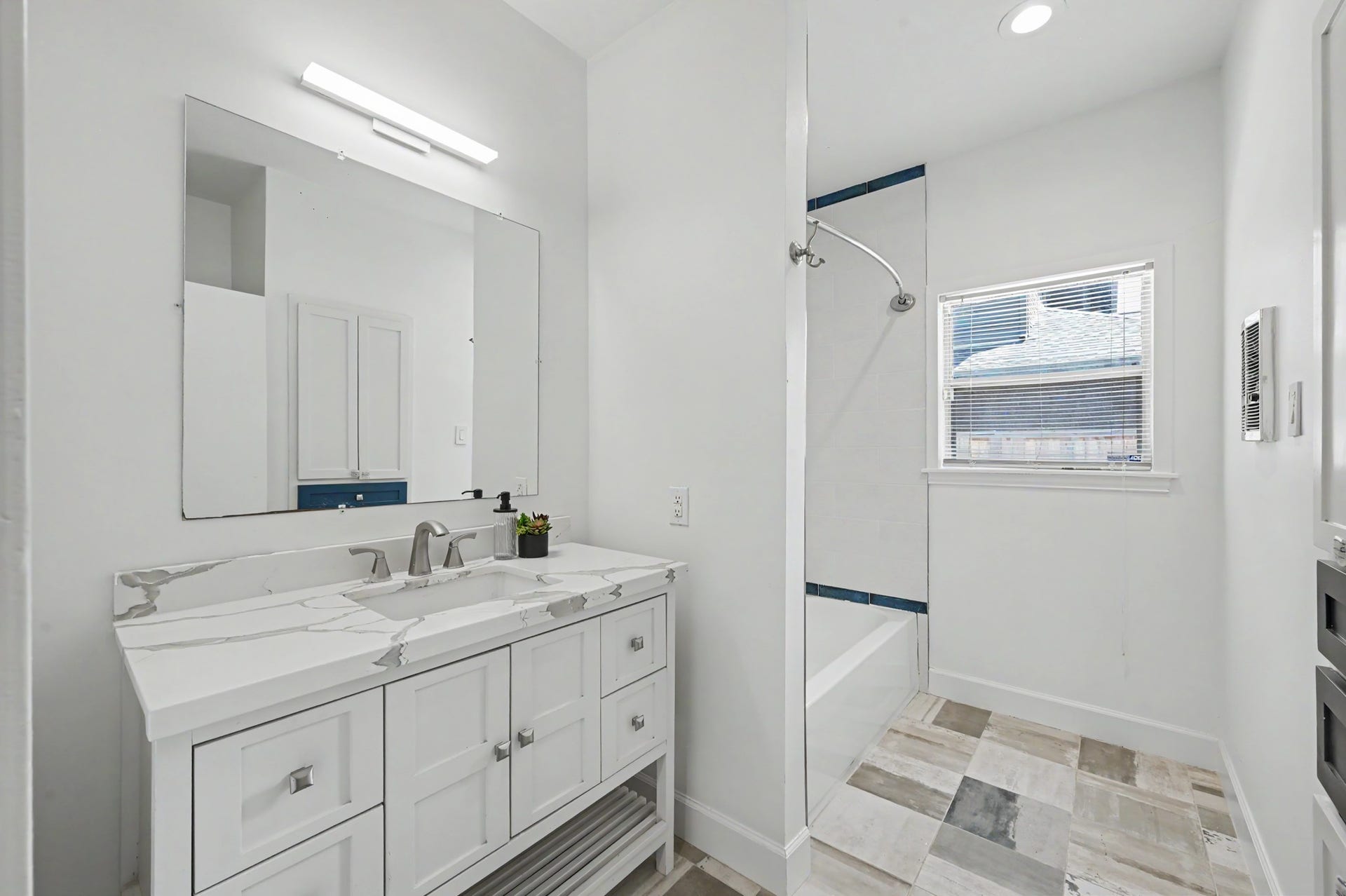 807 Key Street, Houston, TX 77009 Secondary bath with quartz-topped vanity, updated fixtures, tub/shower combination, and contemporary tile flooring.