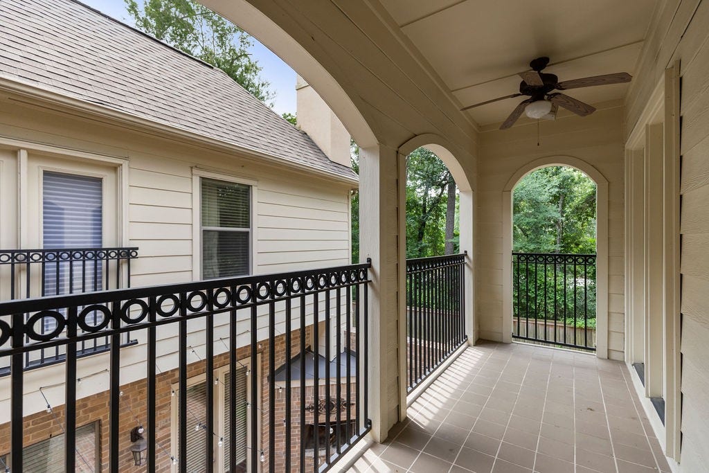 82 Mill Point Place, The Woodlands, TX 77380 The primary bedroom features a large balcony with ceiling fans.