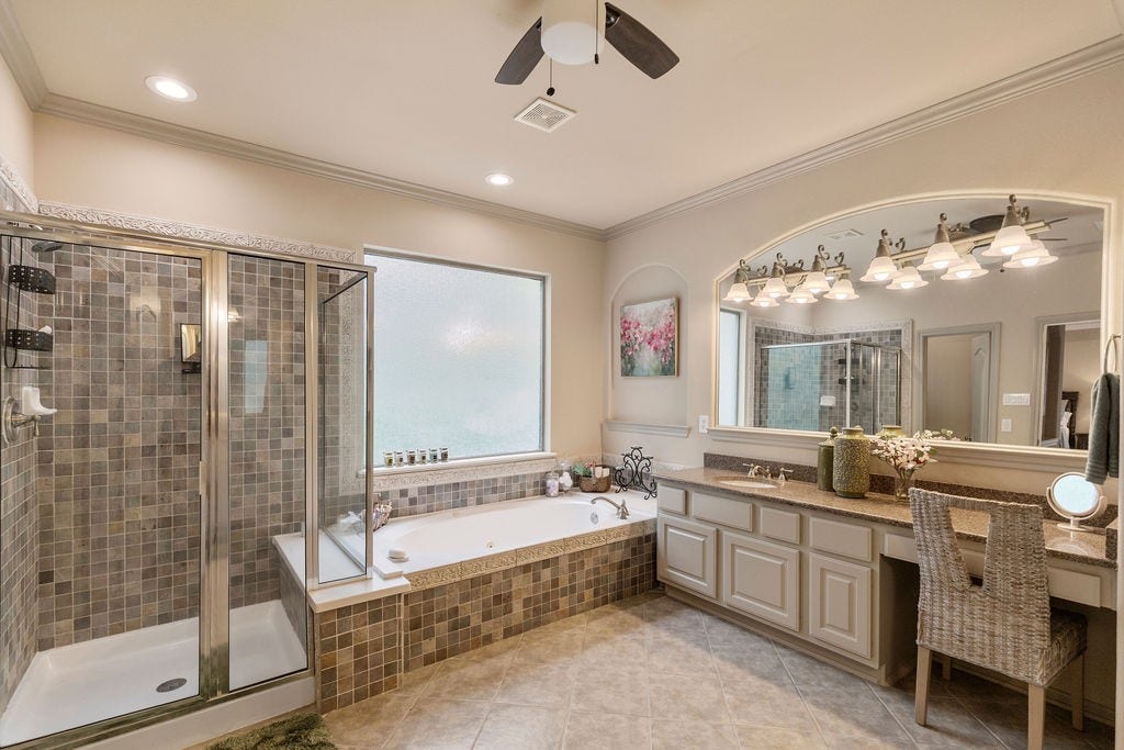 82 Mill Point Place, The Woodlands, TX 77380 The primary bedroom with a standing shower, bathtub and double vanities.