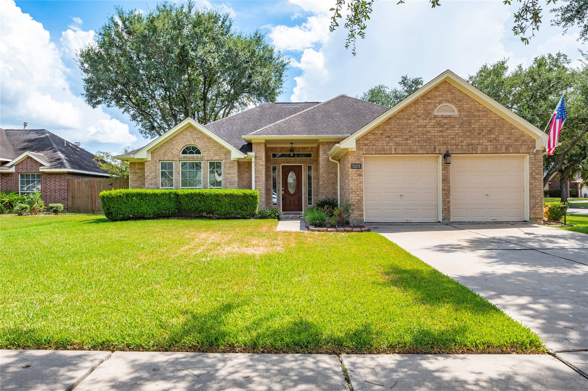 3123 Shore Meadow Drive, League City, TX 77573 Charming brick home with a spacious two-car garage, manicured lawn, and mature trees, offering great curb appeal in a peaceful neighborhood.