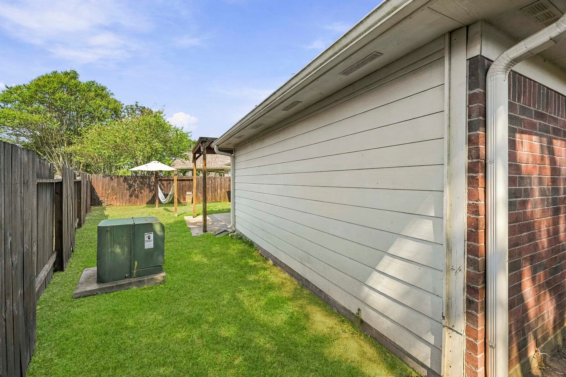 2331 Princess Deanna Lane, Katy, TX 77493 This spacious side yard features a clean, well-maintained lawn bounded by a full wooden privacy fence.
