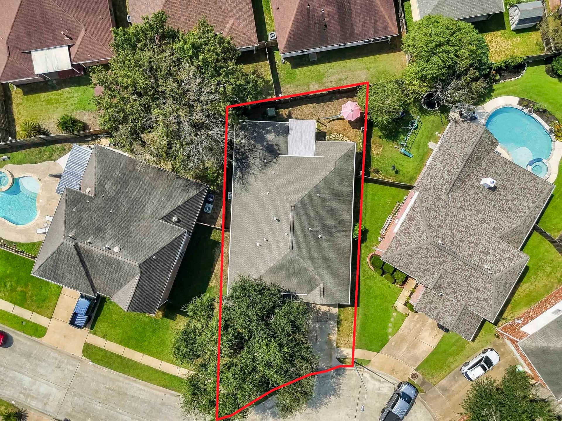 2331 Princess Deanna Lane, Katy, TX 77493 The aerial perspective illustrates the functional layout of the green front lawn, long concrete driveway, covered back patio extension, and enclosed yard space.