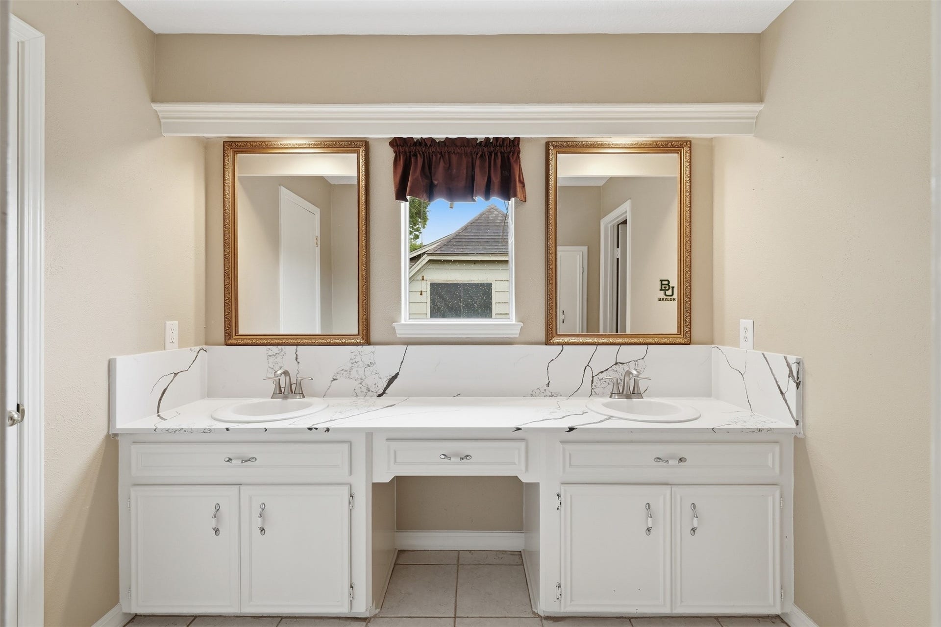 Upstairs bathroom features dual sinks, providing added convenience for busy mornings.