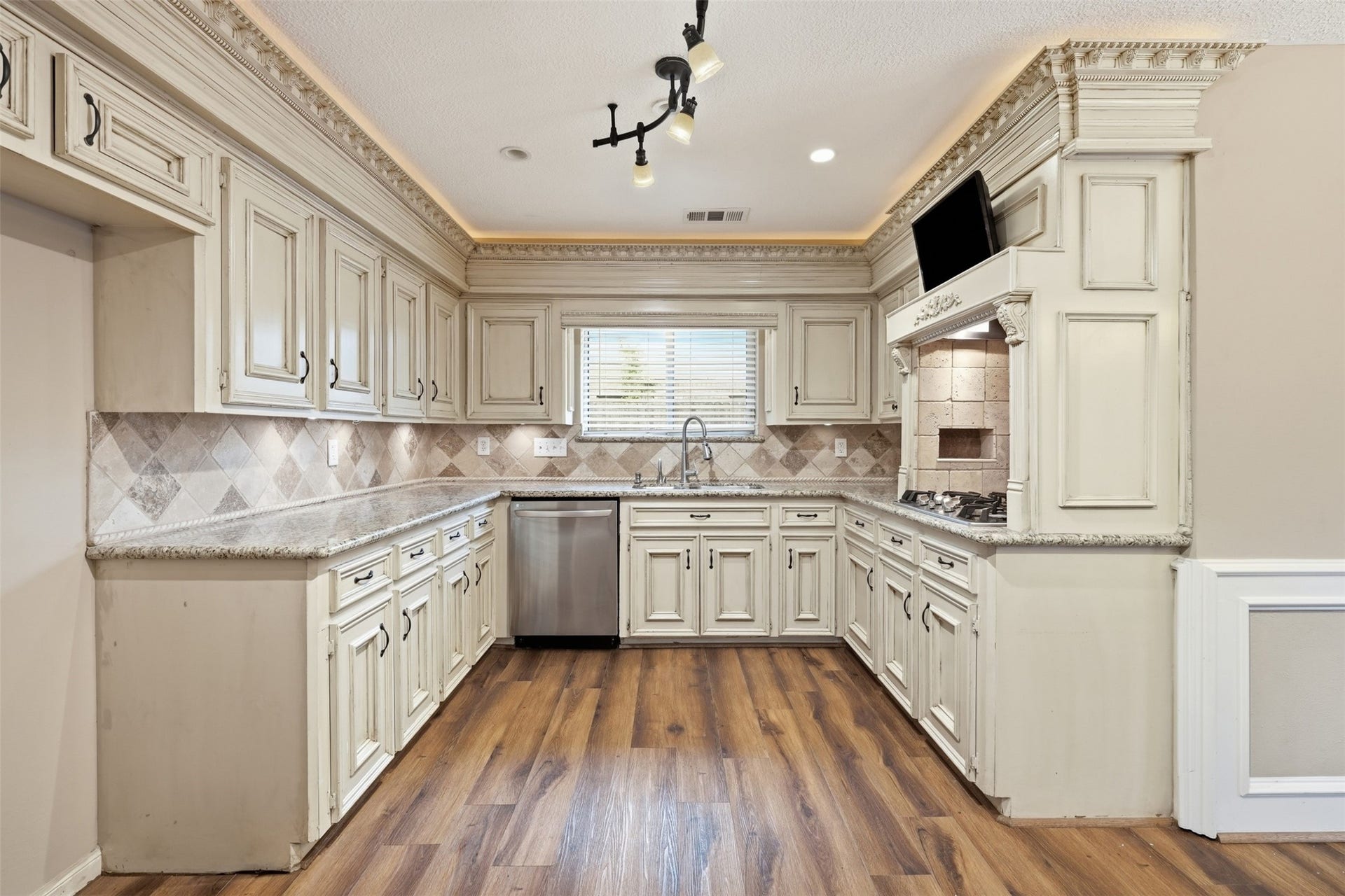 The beautifully appointed kitchen offers abundant cabinetry, generous countertop space, and a layout designed for both everyday cooking and entertaining.