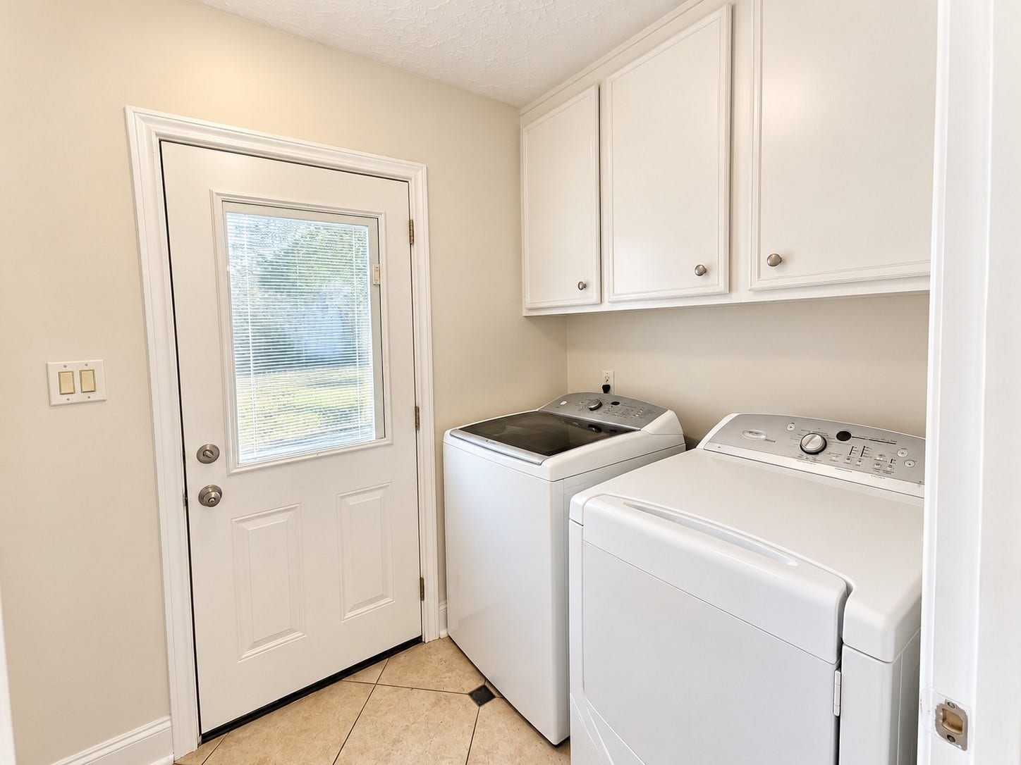 Washer and Dryer room leading out to the covered walkway next to the garage