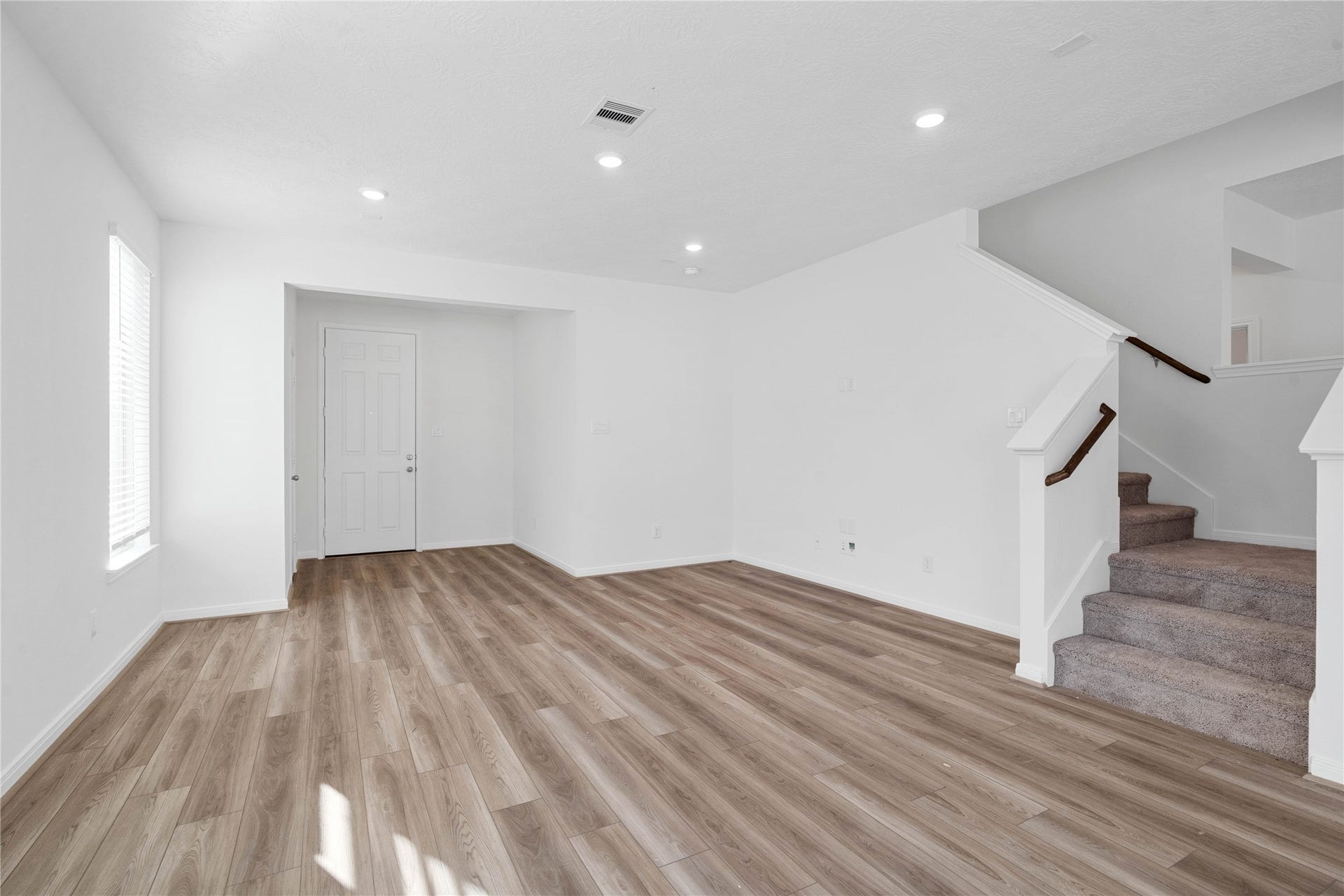 5623 Blackbird Lane, Hitchcock, TX 77563 The spacious living room features warm wood look flooring, recessed lighting, and large windows that fill the space with natural light. Its open layout creates a comfortable setting for relaxing or gathering with family and friends.