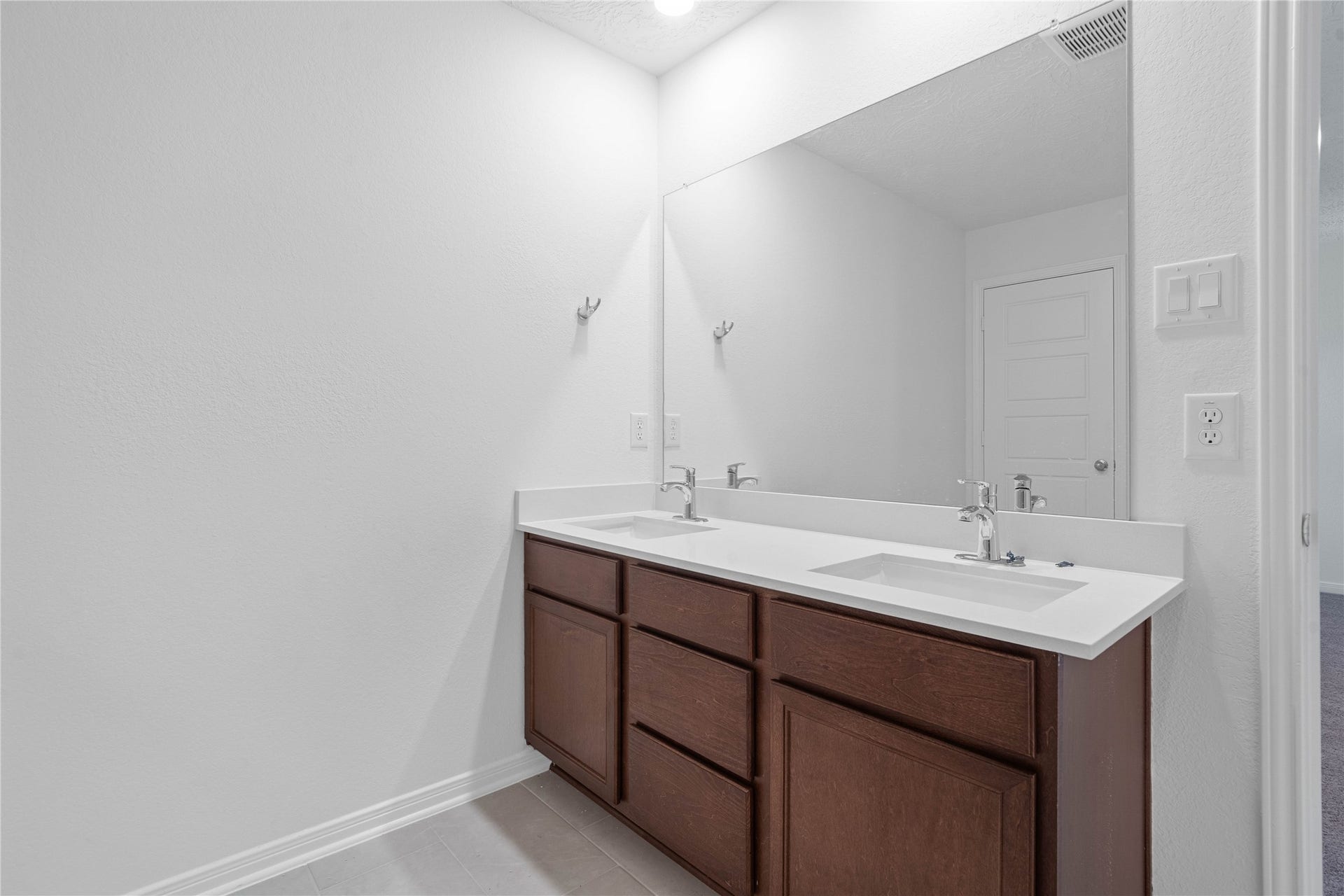 5623 Blackbird Lane, Hitchcock, TX 77563 The primary bathroom features a dual sink vanity, offering added convenience for busy mornings and everyday routines. A clean, neutral palette and Heirloom White tile surround create a fresh, timeless look.