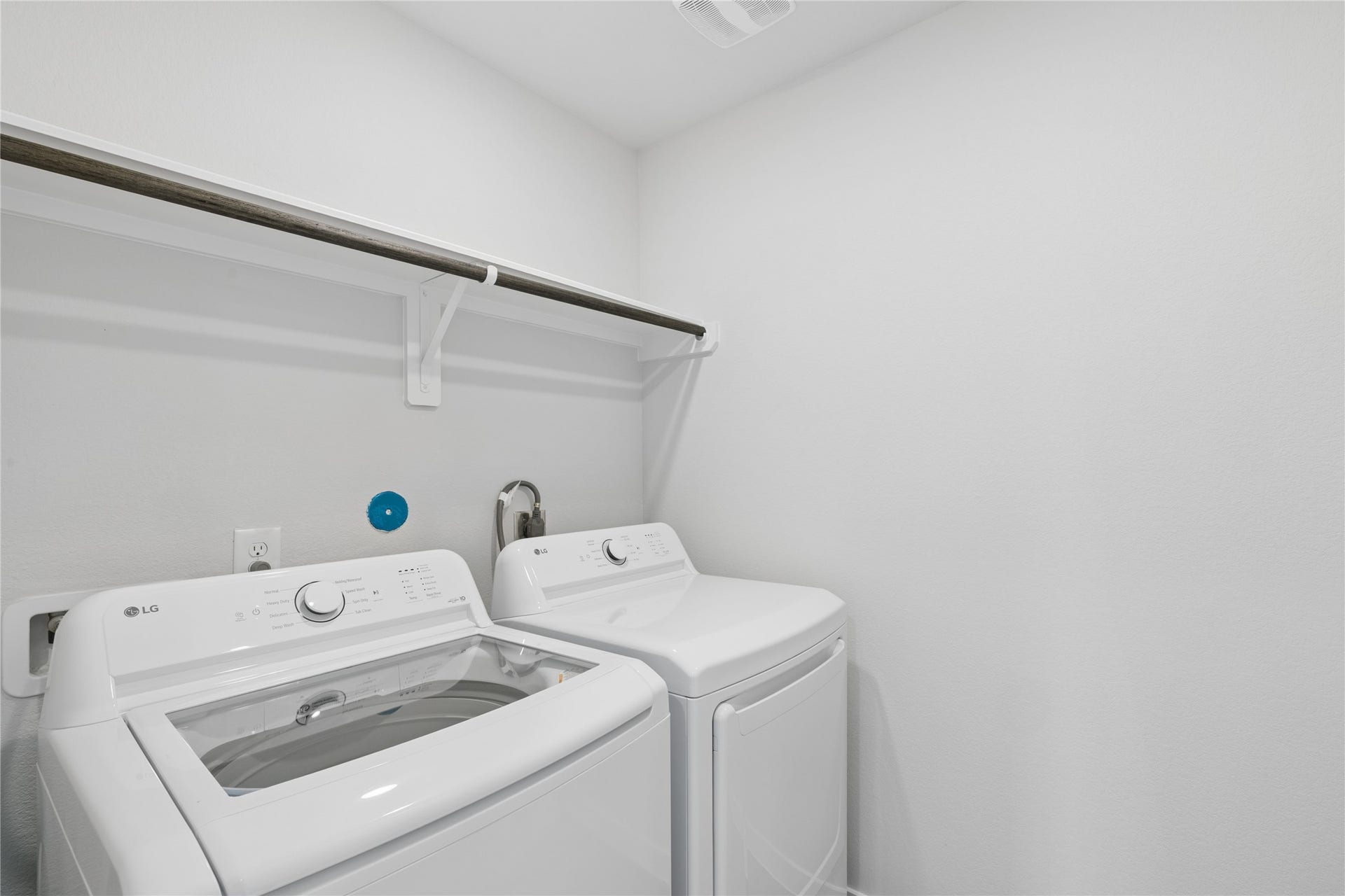7806 Bergamot Cir, Magnolia, TX 77354 Effortlessly manage your laundry in this bright, organized space featuring modern washer and dryer with convenient shelving for all your essentials.