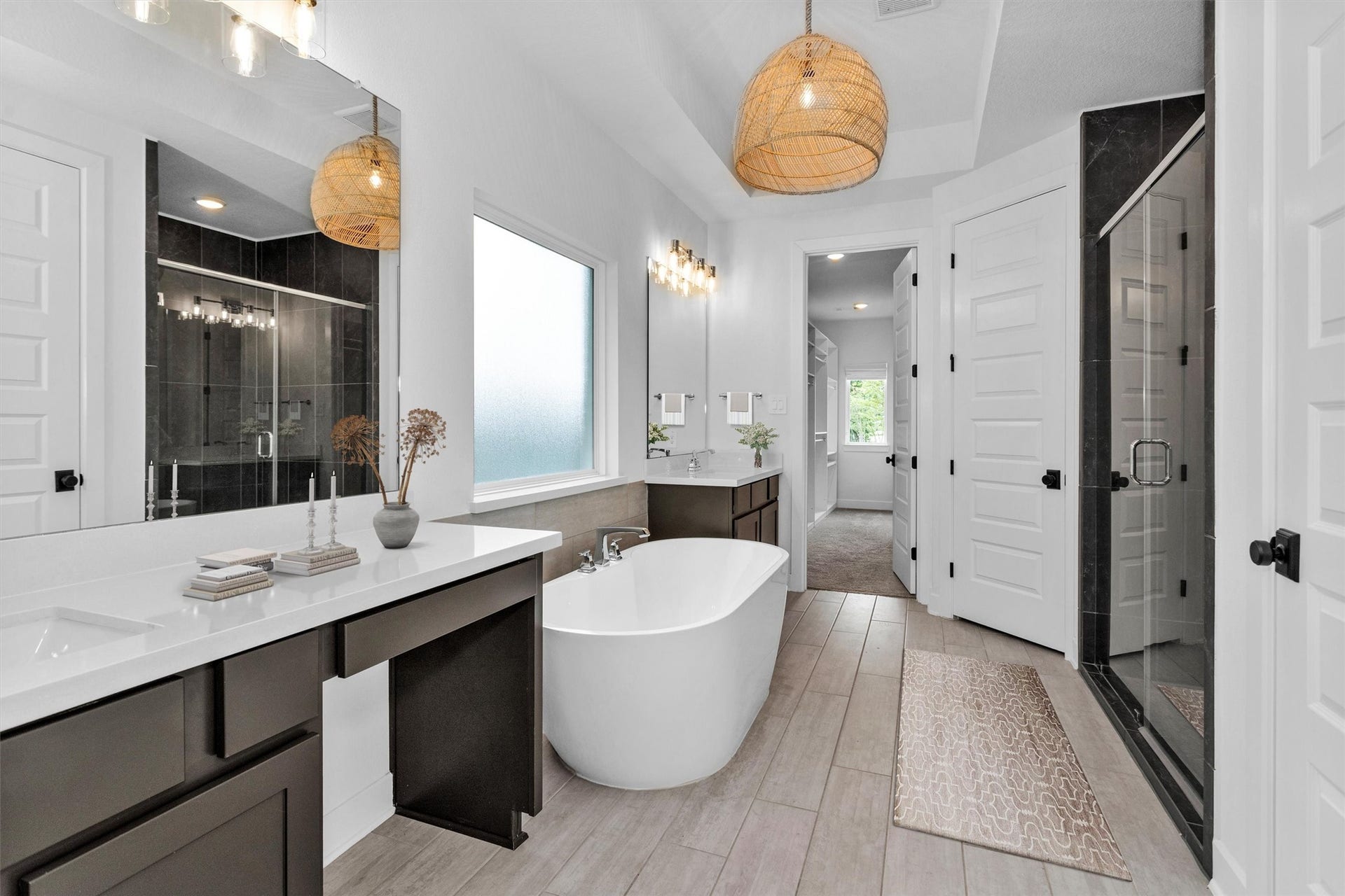 Luxurious primary bath featuring an upgraded soaking tub, separate walk-in shower, dual vanities, and an incredible closet w/built-inscreating a spa-like retreat designed for everyday indulgence.