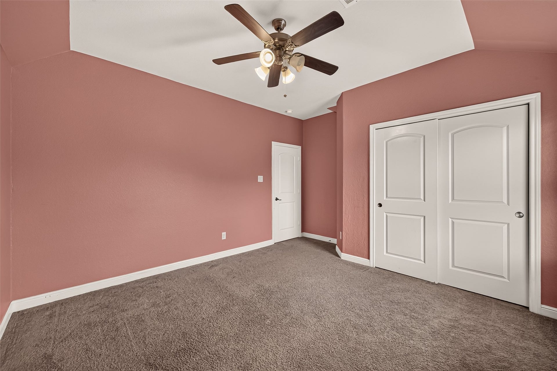 2826 Verdant Spring Trail, Katy, TX 77493 Charming fourth bedroom featuring soft pink walls, plush carpeting, a stylish ceiling fan, and generous closet space with elegant white sliding doors.