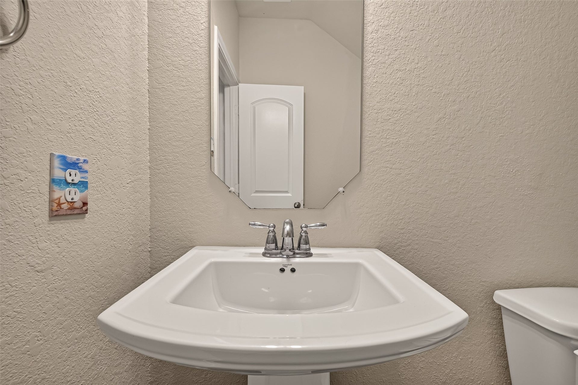 2826 Verdant Spring Trail, Katy, TX 77493 Charming powder room with a sleek pedestal sink, elegant mirror, and neutral tones, offering a cozy and functional space.