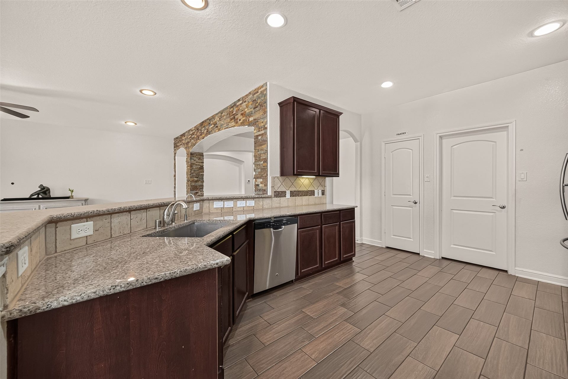 2826 Verdant Spring Trail, Katy, TX 77493 Another view of the spacious kitchen with rich wood cabinetry, sleek granite countertops, and modern stainless steel appliances.