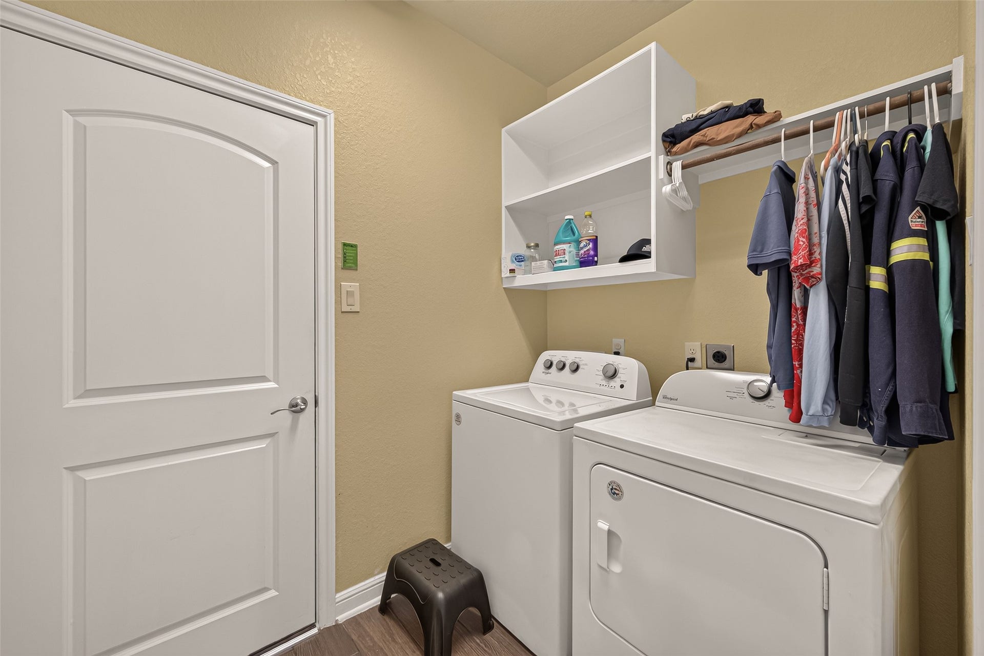 2826 Verdant Spring Trail, Katy, TX 77493 Efficient laundry room with a washer and dryer, open shelving for storage, and a convenient hanging rod for clothes.