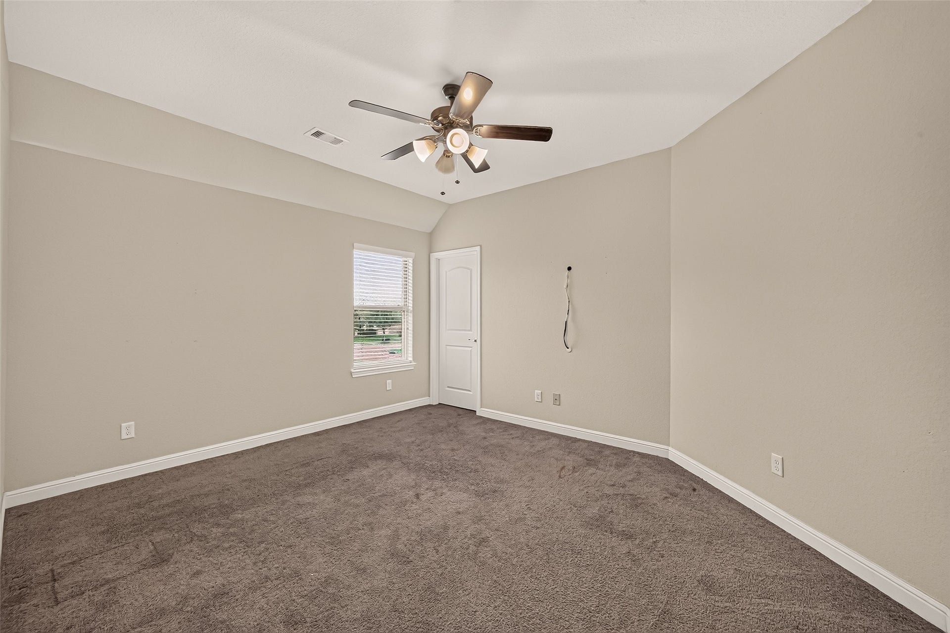 2826 Verdant Spring Trail, Katy, TX 77493 Spacious fifth bedroom featuring plush carpeting, a modern ceiling fan, and abundant natural light, creating a warm and inviting retreat.