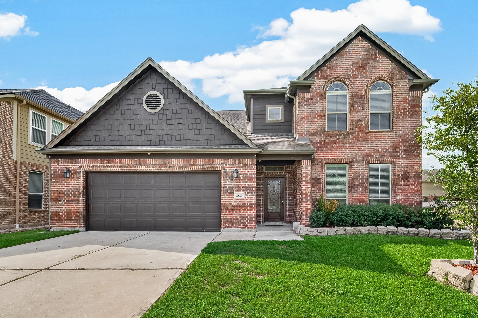 2826 Verdant Spring Trail, Katy, TX 77493 Charming two-story brick home featuring a spacious driveway, attached garage, and well-kept front lawn in a quiet neighborhood.