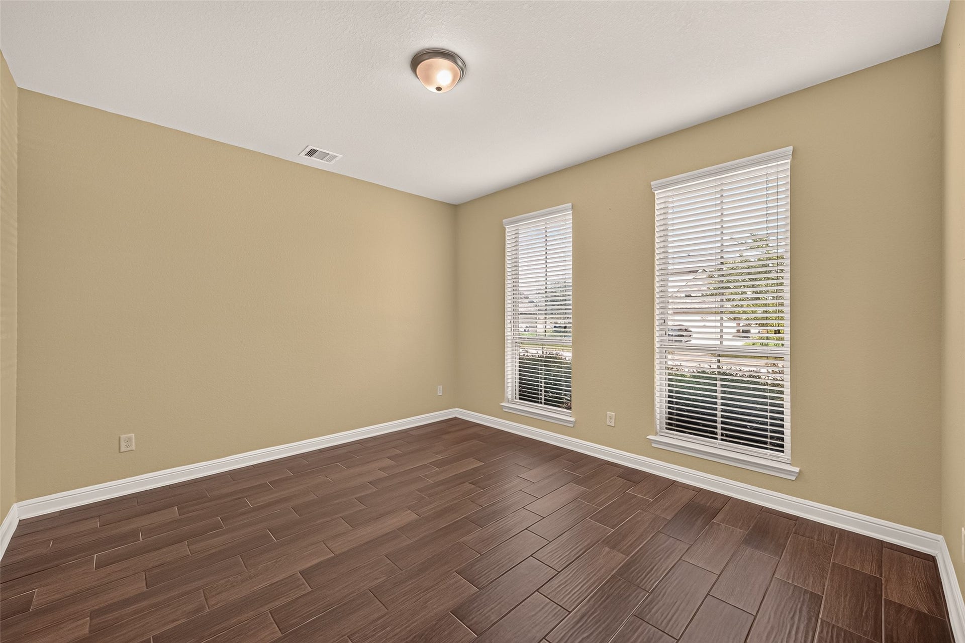 2826 Verdant Spring Trail, Katy, TX 77493 Bright office featuring elegant wood-look tile flooring and abundant natural light from two large windows with blinds.