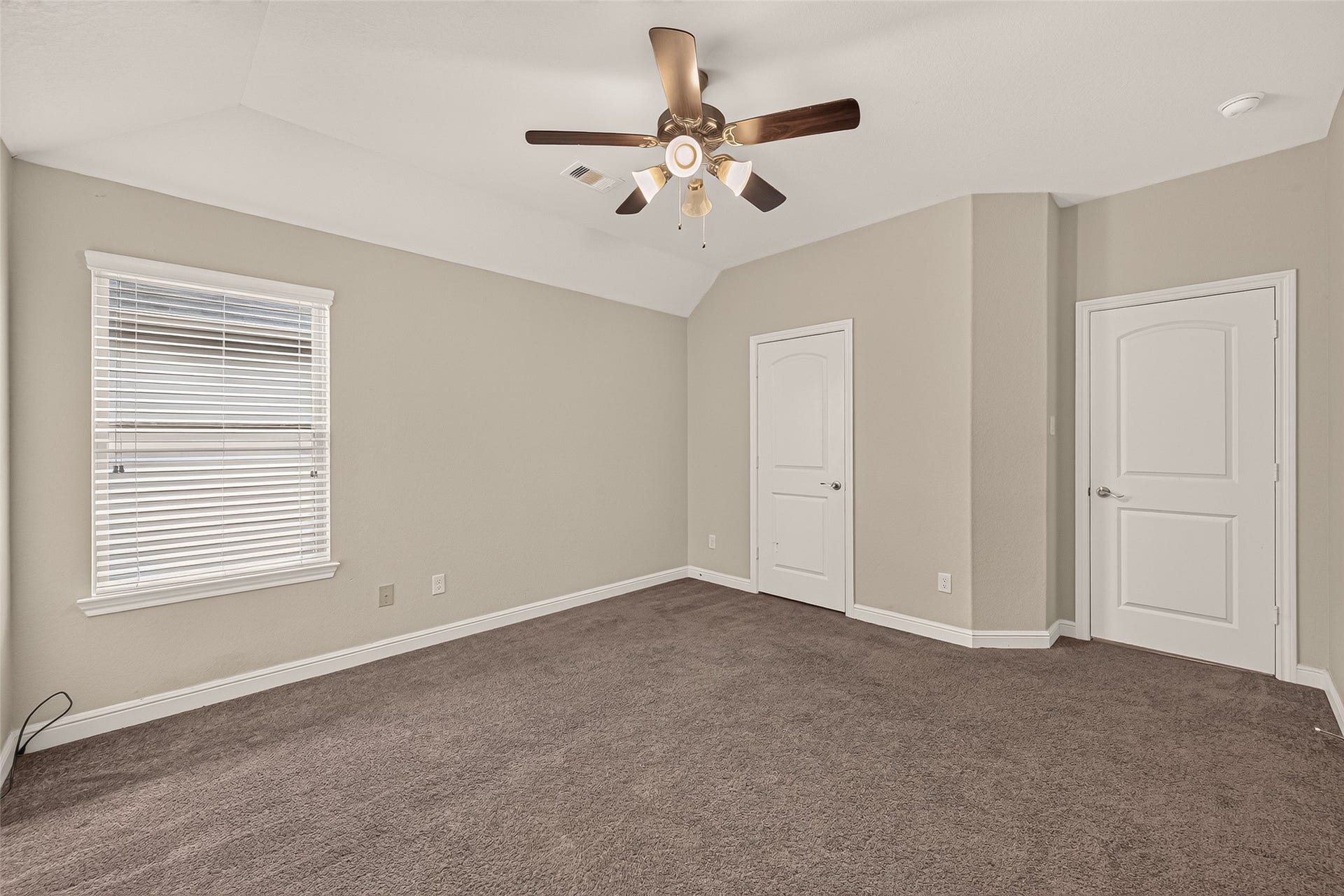 2826 Verdant Spring Trail, Katy, TX 77493 Spacious secondary bedroom featuring plush carpeting, neutral tones, a ceiling fan, abundant natural light, and dual closets.