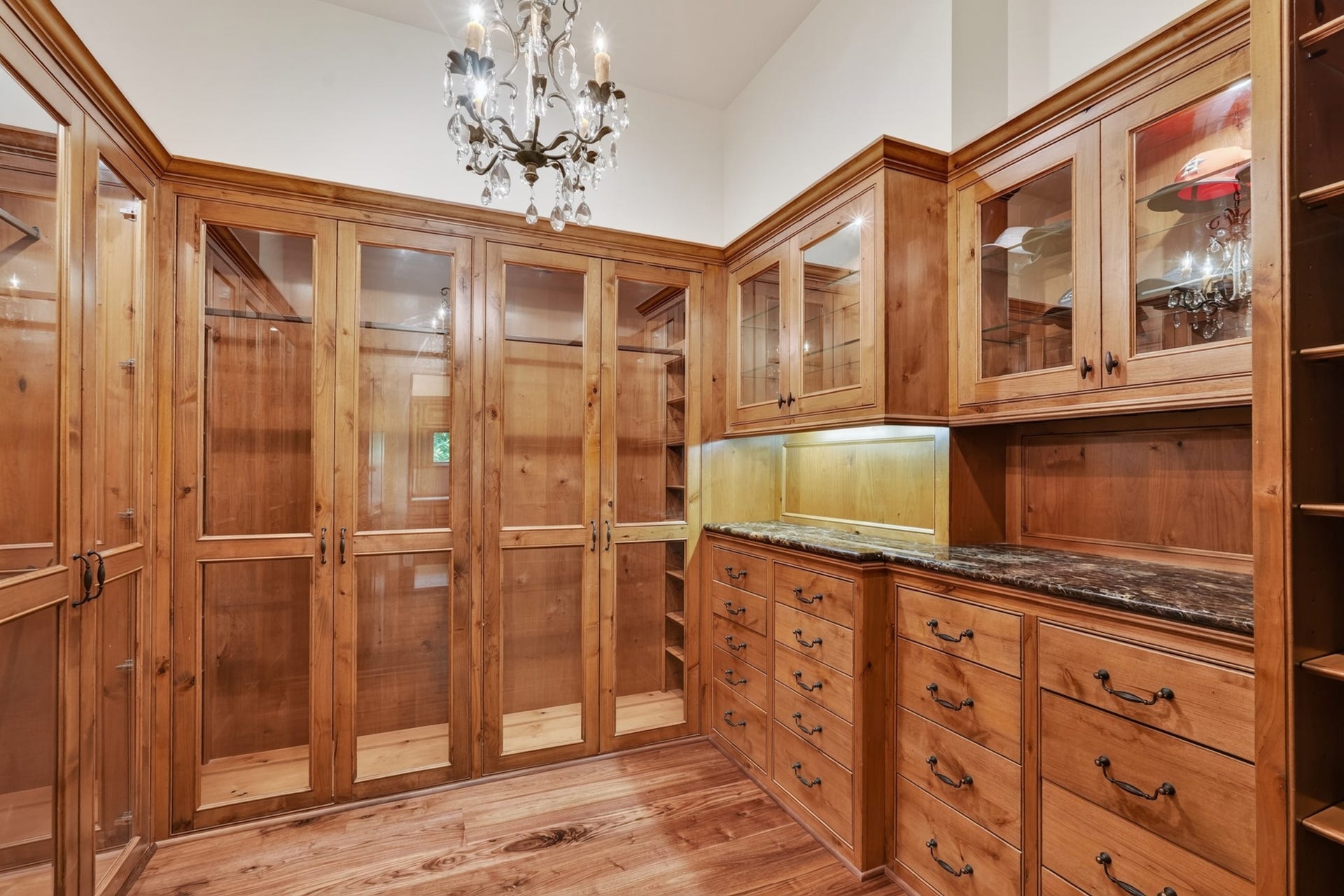 247 S Fazio Way, Spring, TX 77389 One of 2 expansive designer primary closets featuring floor-to-ceiling cabinetry, glass display doors, granite countertops, and abundant storage.