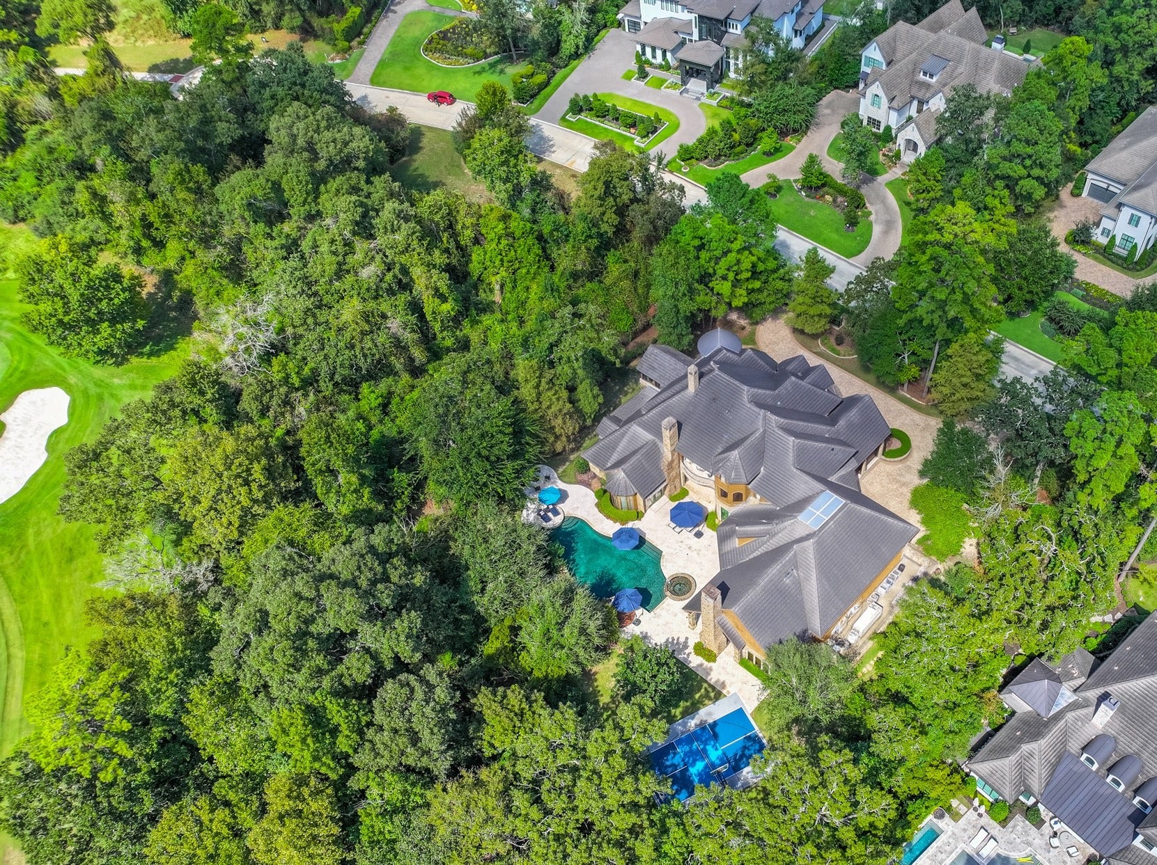 247 S Fazio Way, Spring, TX 77389 Tucked away on a secluded, tree-lined lot in the prestigious Carlton Woods, this one-of-a-kind estate seamlessly blends luxury, privacy, and resort-style living.