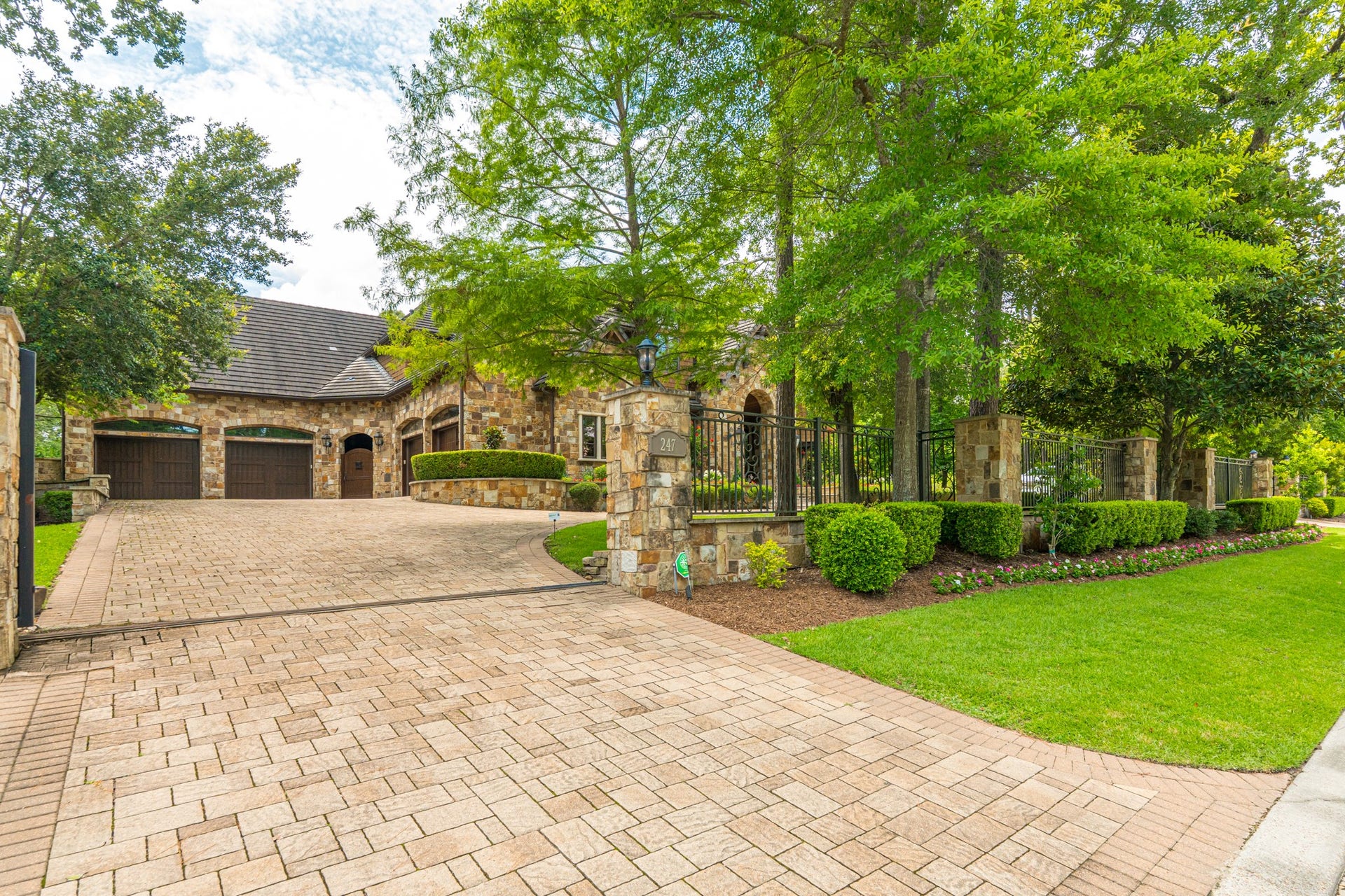 247 S Fazio Way, Spring, TX 77389 A private gated entrance, one of the few in Carlton Woods, along with an broad paver driveway, and beautifully manicured landscaping create a grand first impression, offering both elegance and exclusivity from the moment you arrive. 6 car garage.