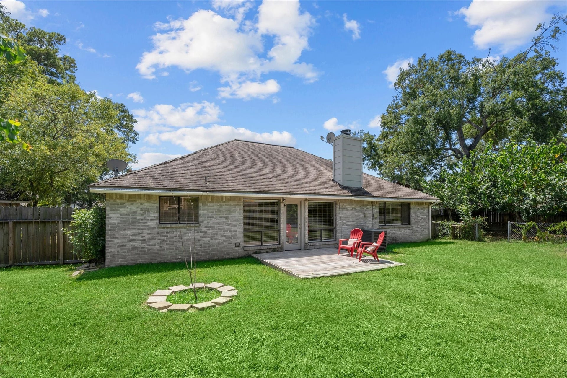 An expansive lawn extends behind the home, offering room for outdoor activities, play, or gardening.