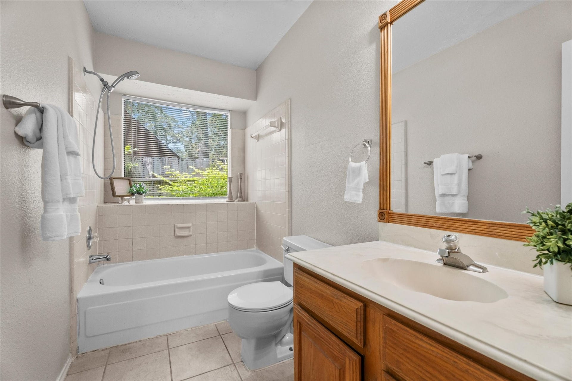 The full secondary bathroom has a tub/shower combination, vanity with ample counter space, and a window for natural light.