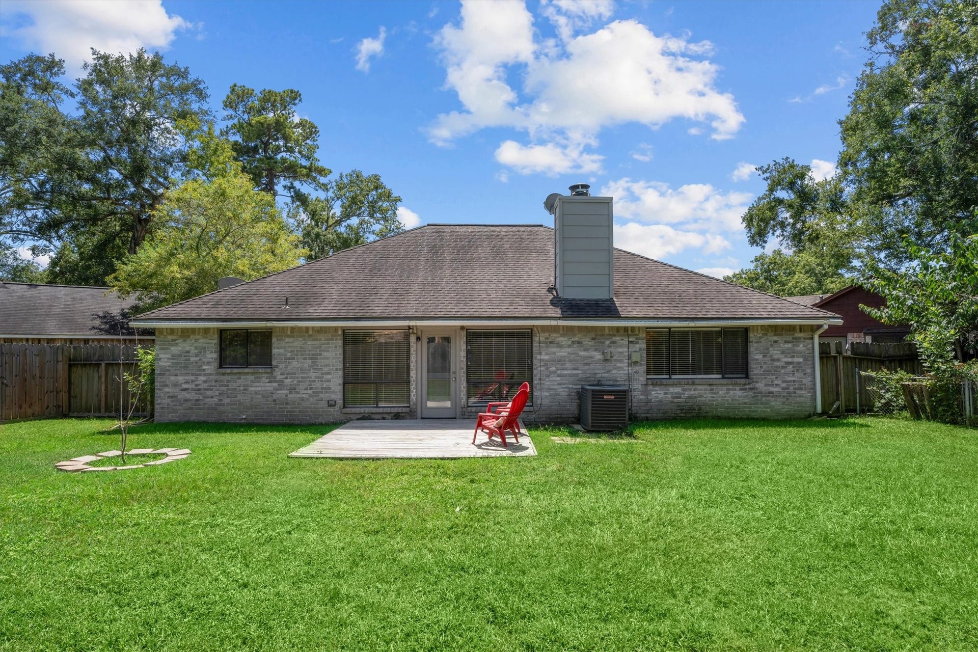 The brick rear exterior offers multiple windows and direct access to the backyard, bringing the indoor and outdoor spaces together.