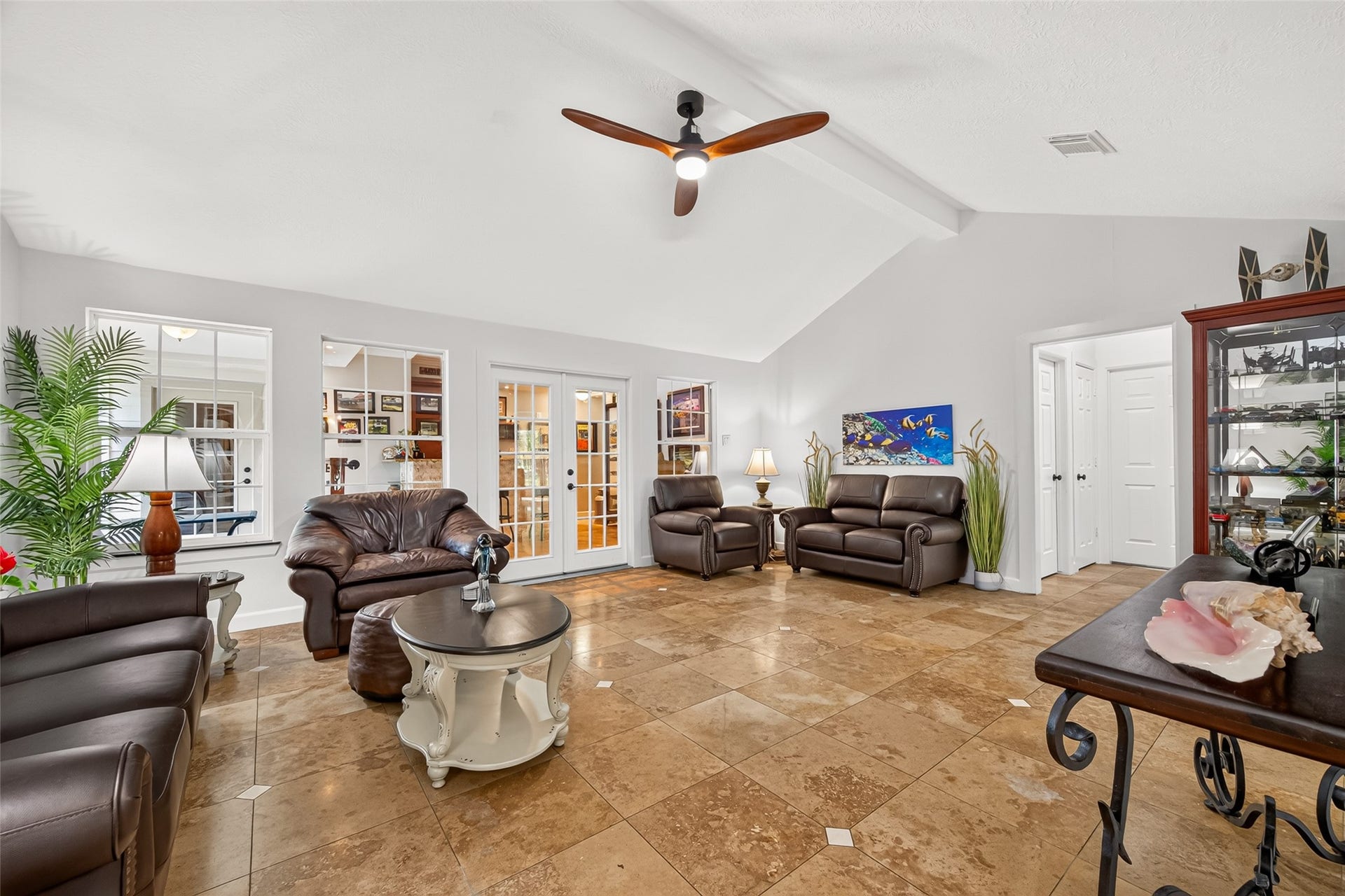 Another view of the spacious main living area, highlighting the vaulted ceiling, tile flooring and easy flow into the surrounding rooms.