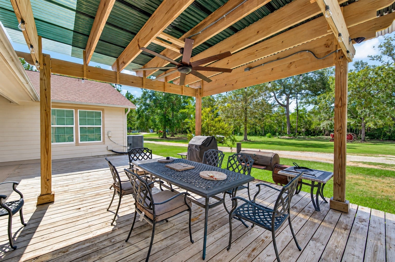 Covered outdoor entertaining area with expansive deck, ceiling fan and plenty of space for dining and relaxing.