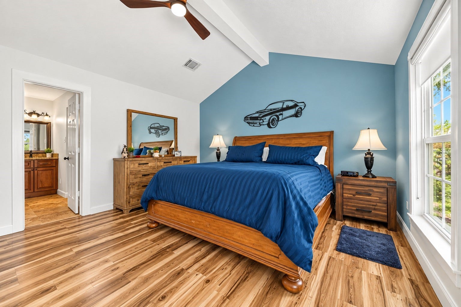 Spacious primary bedroom with vaulted ceiling, abundant natural light and private access to the en-suite bath.