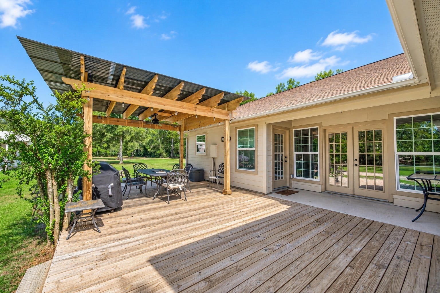 Spacious outdoor patio and deck with covered seating area and direct access to the attached guest suite.