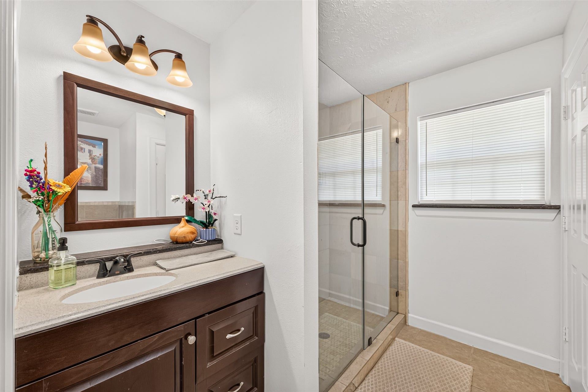 Guest Suite Bathroom  Private full bath with vanity and a spacious glass-enclosed walk-in shower.