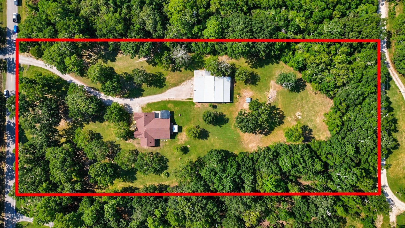 Overhead aerial with property boundaries outlined, showcasing the home, large shop, open acreage, and mature trees.