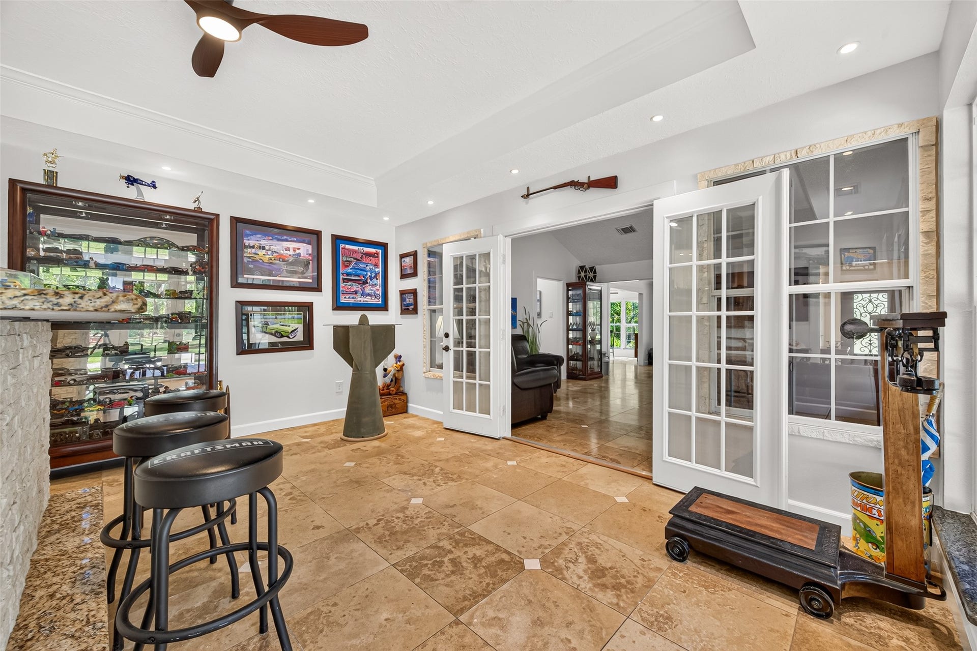 Game room with French doors connecting to the main living area and convenient access to the kitchen.