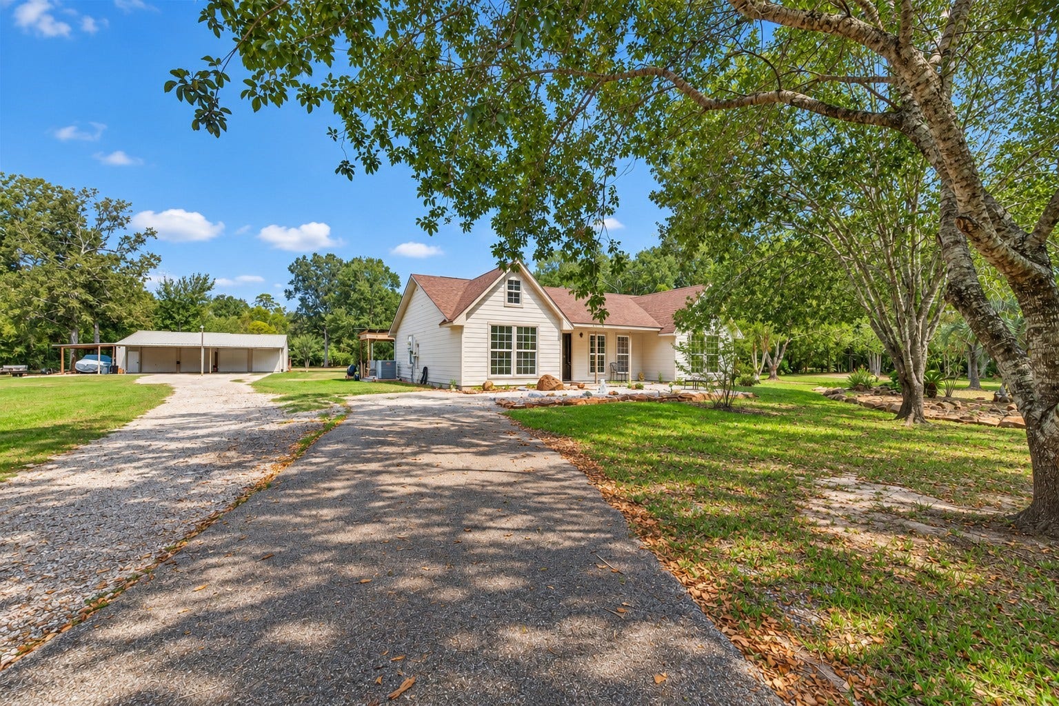 A closer look at the home and detached workshop, surrounded by mature trees on 5.34 acres.