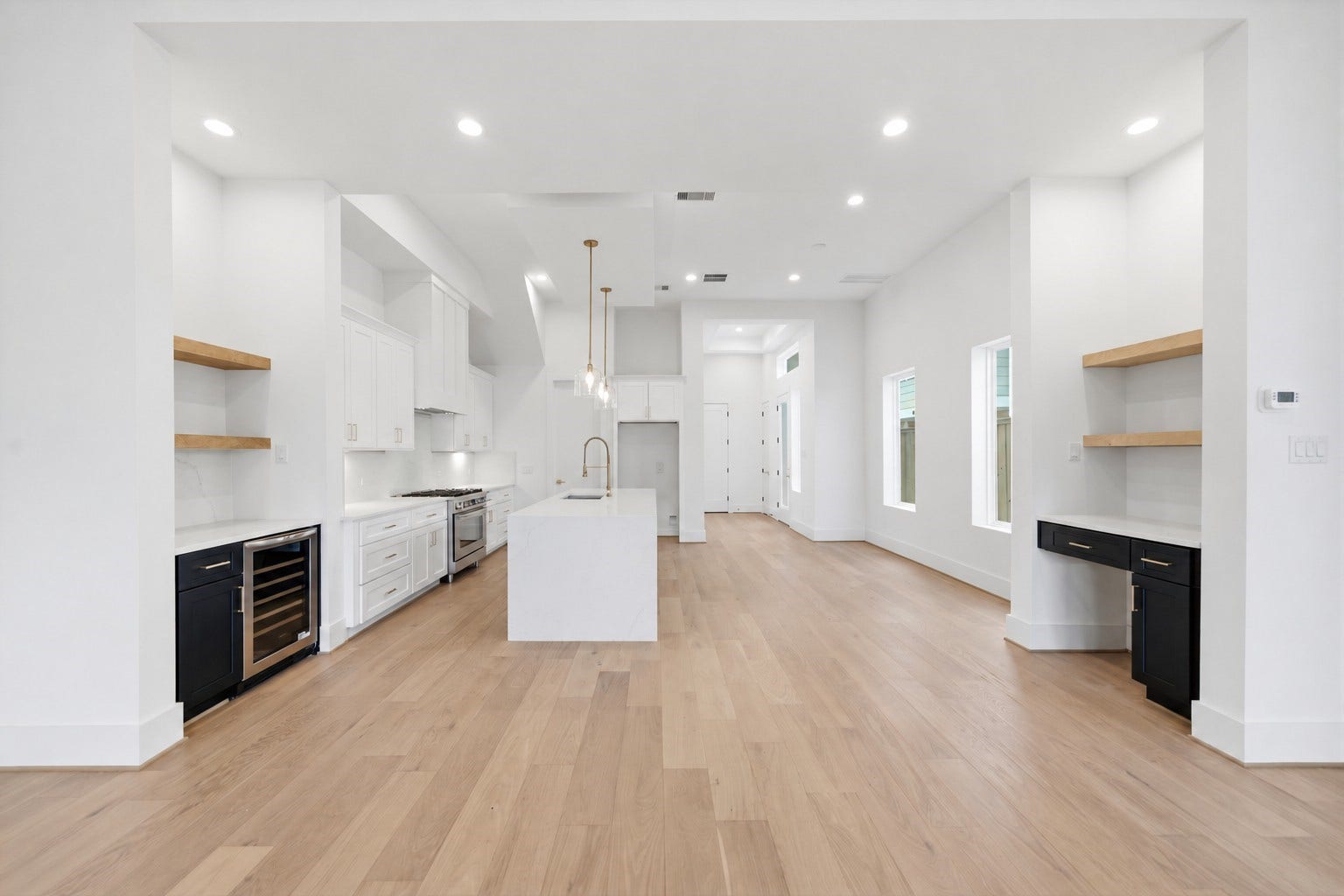 Reverse view of living are looking into the large dining area and modern, open kitchen.