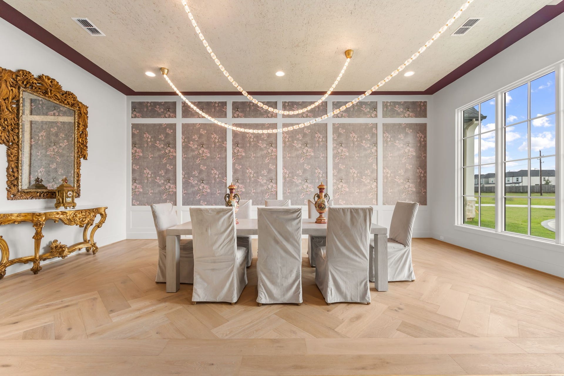 4233 Two Gun Way, Katy, TX 77494 Large banquet sized formal dining room with rug pattern in hardwood floors and unique strands of crystal with gold accented light fixture.