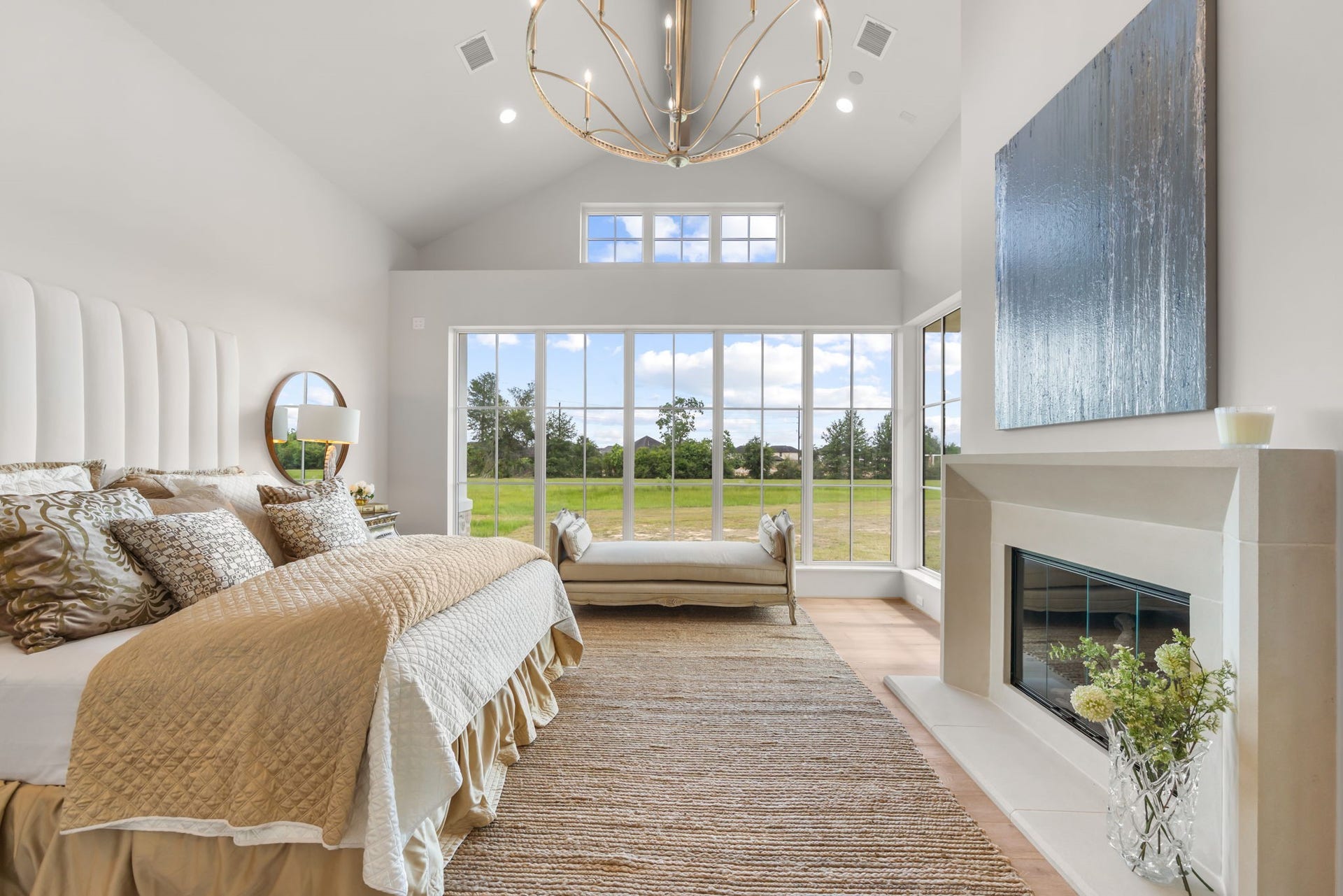 4233 Two Gun Way, Katy, TX 77494 Lavish primary suite with walls of windows, cast stone fireplace and dramatic gold accented chandelier.