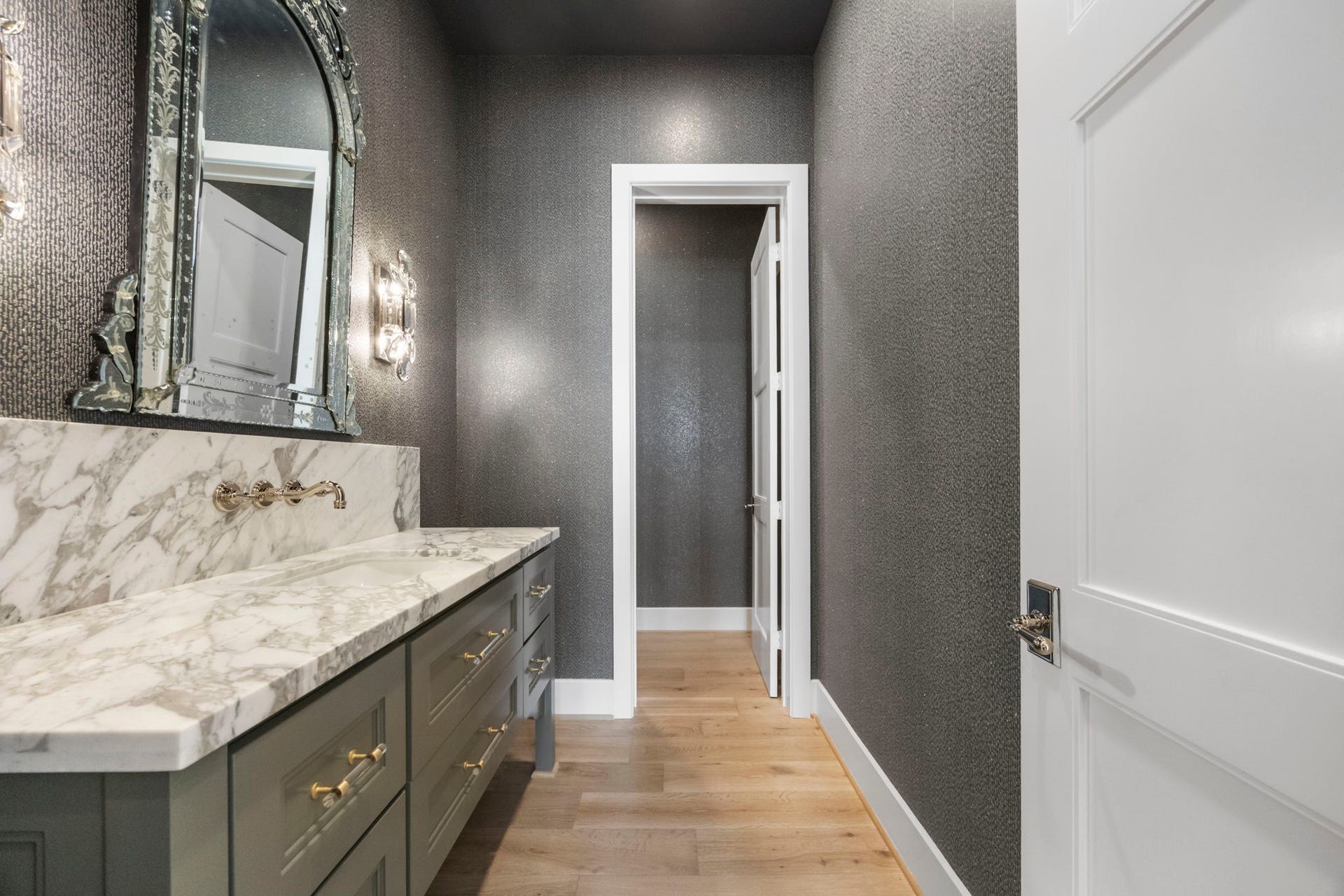 4233 Two Gun Way, Katy, TX 77494 Stunning powder room off entry with lux vanity, mirror, sconces, and wallpaper.