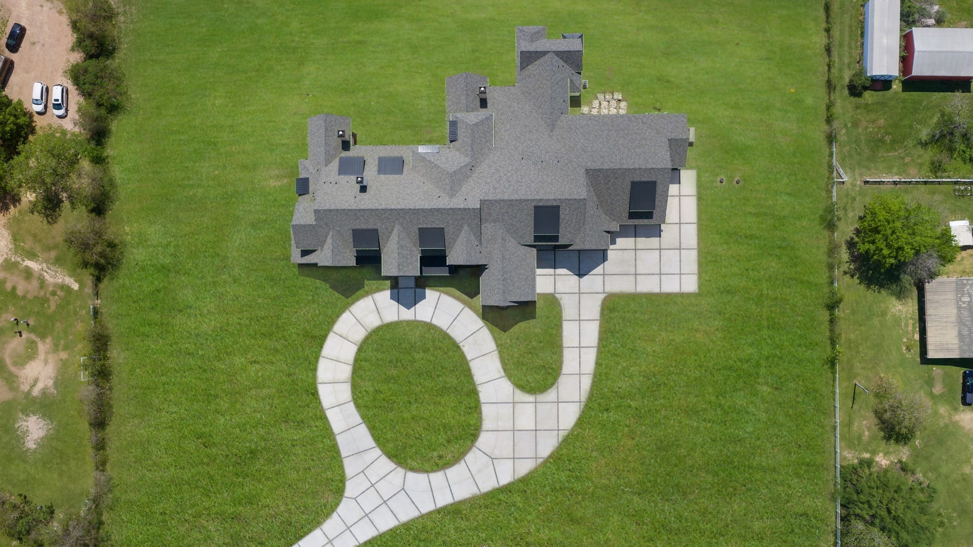 4233 Two Gun Way, Katy, TX 77494 Aerial view of the house with digitally enhanced grass showing the large circular driveway with extra parking outside the 6 car garage.