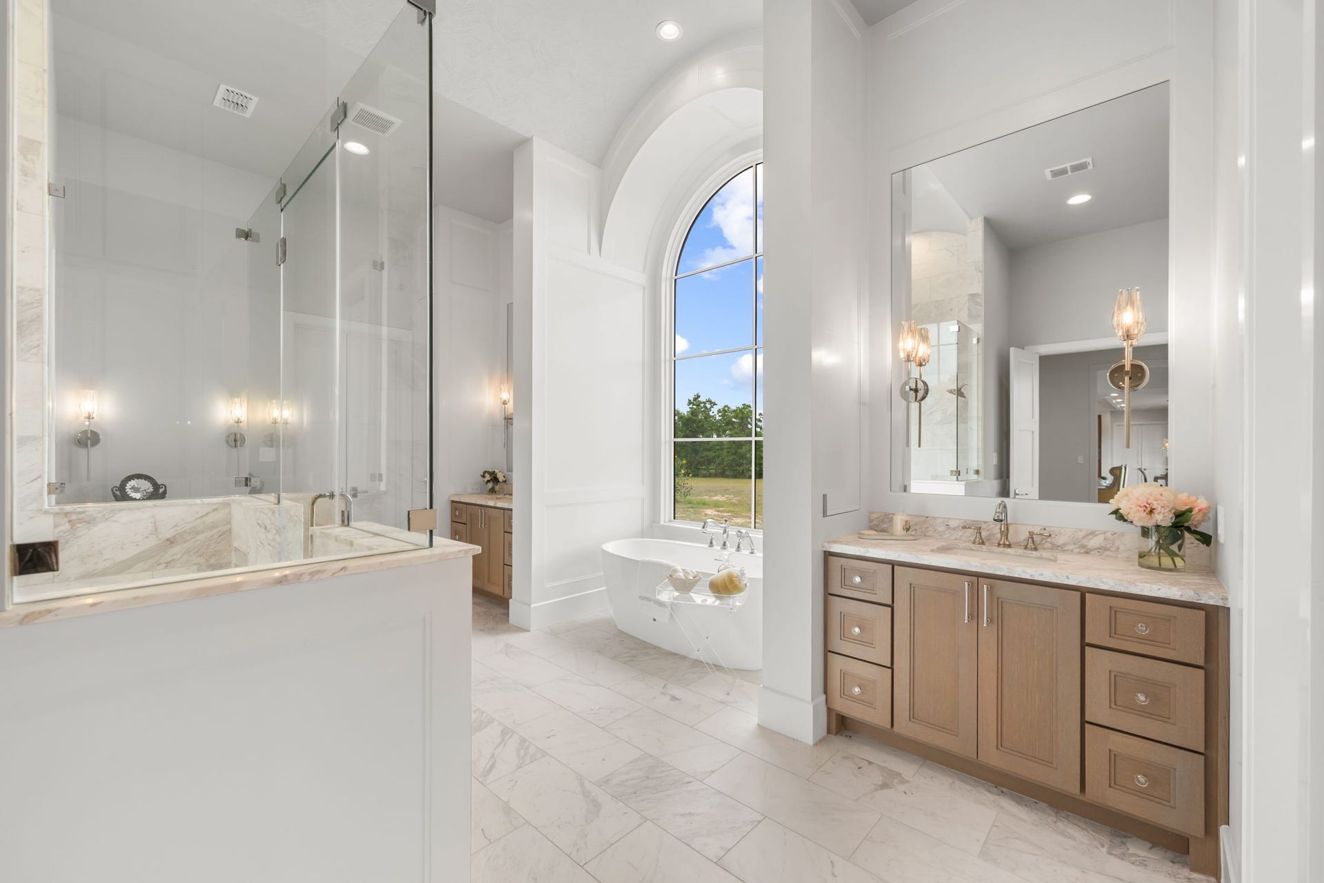 4233 Two Gun Way, Katy, TX 77494 Stunning primary bath with large walk-in shower, soaking tub, two vanities with sinks and a third sit down vanity all with sconce lighting in addition to overhead lighting.
