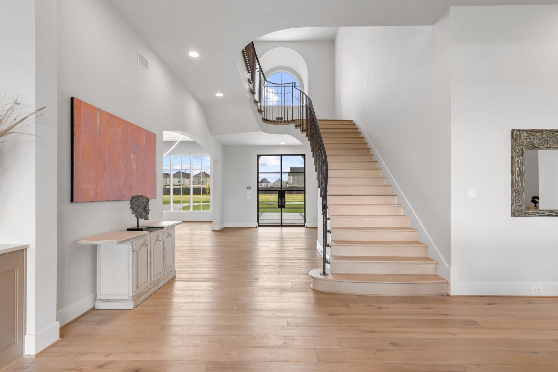 4233 Two Gun Way, Katy, TX 77494 View straight into the grand entry foyer with sweeping stair case. The formal dining is the left through the curved arch.