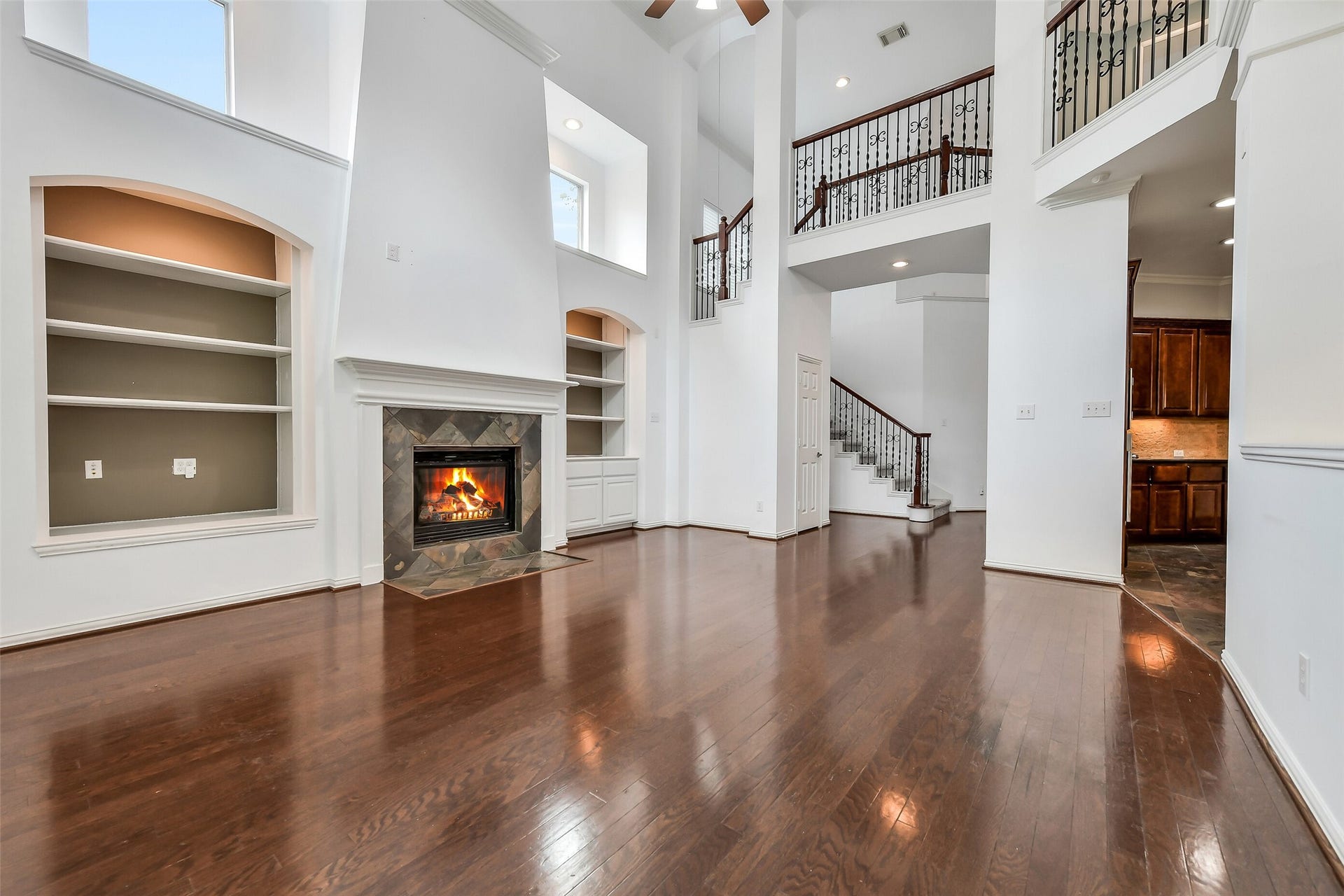 8407 Alyssa Gardens Lane, Humble, TX 77396 This view showcases one of the home's two stairways with classic wrought-iron railings, highlighting the effortless open layout between the living room and kitchen. Wired for surround sound.